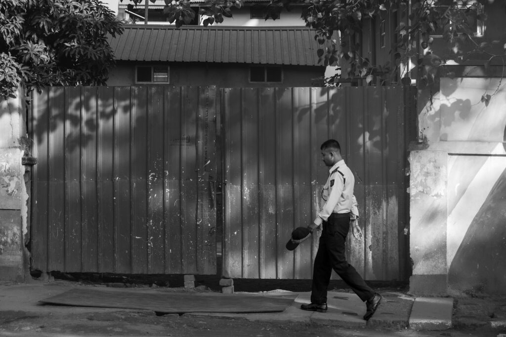 A black and white photo of a man walking down the street