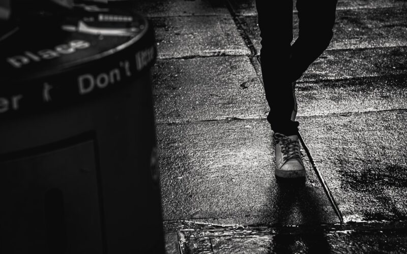 a person walking down a sidewalk in the rain
