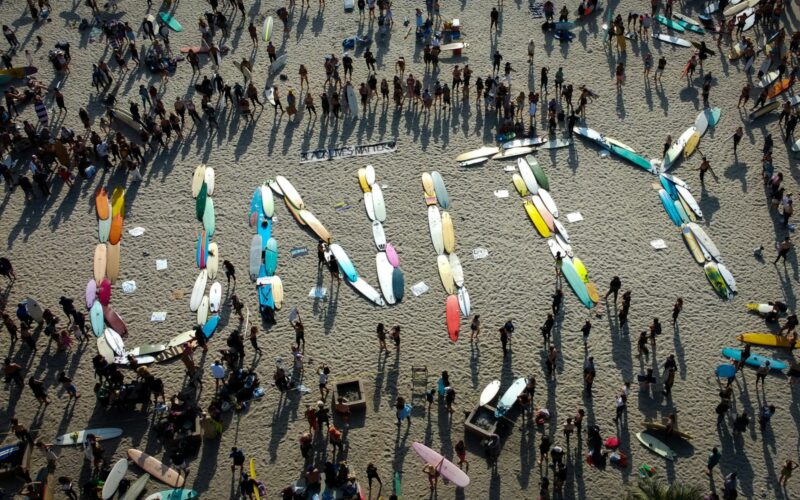 a group of people standing on top of a sandy beach