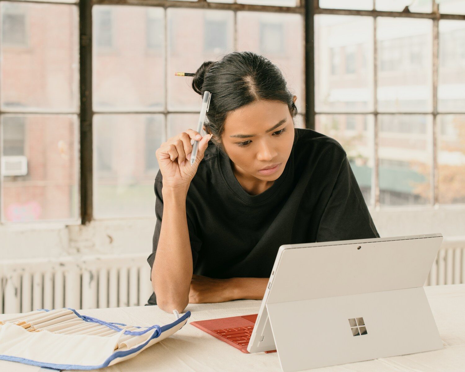 a woman sitting at a table using a laptop computer