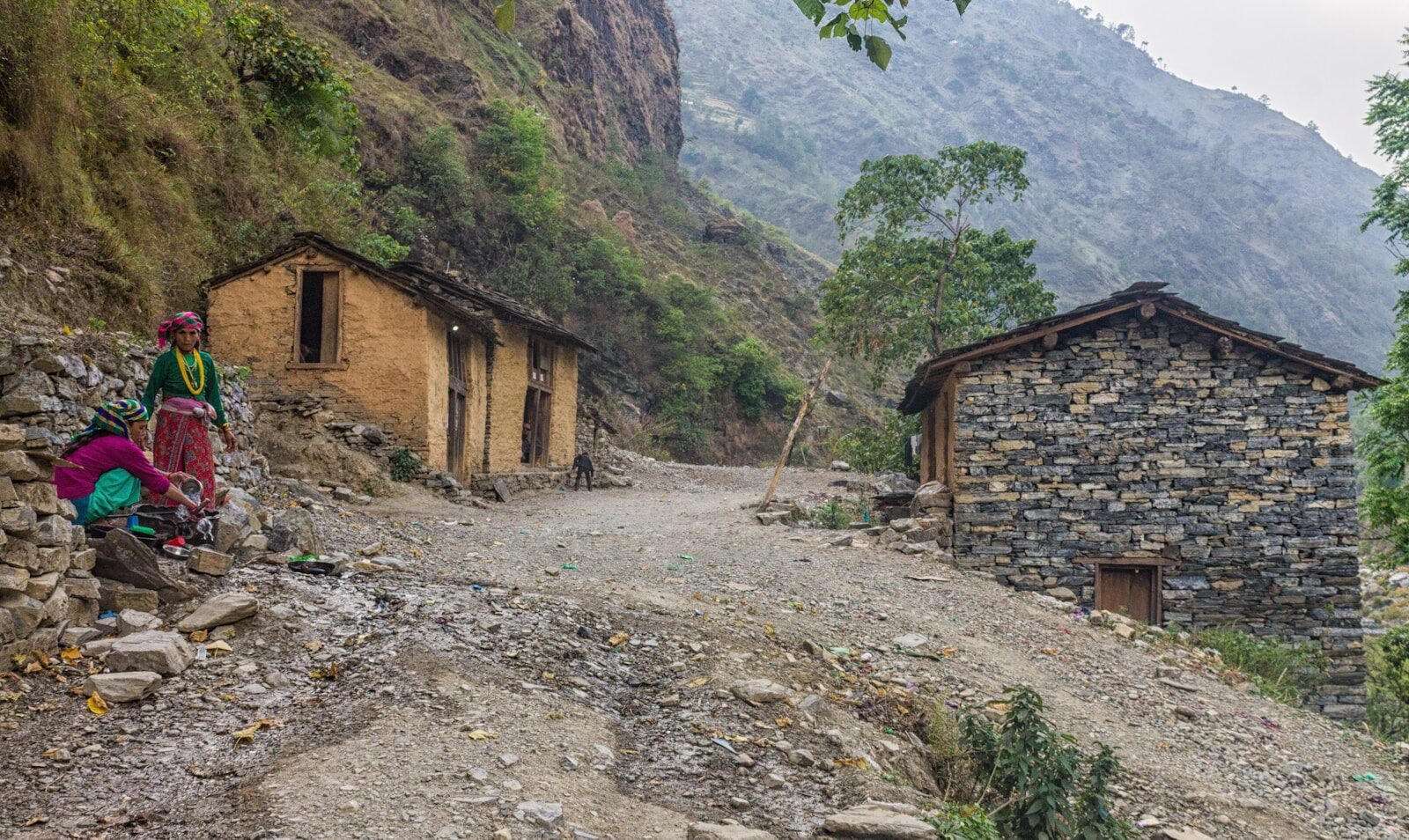 Two rustic houses on a dirt road in the mountains