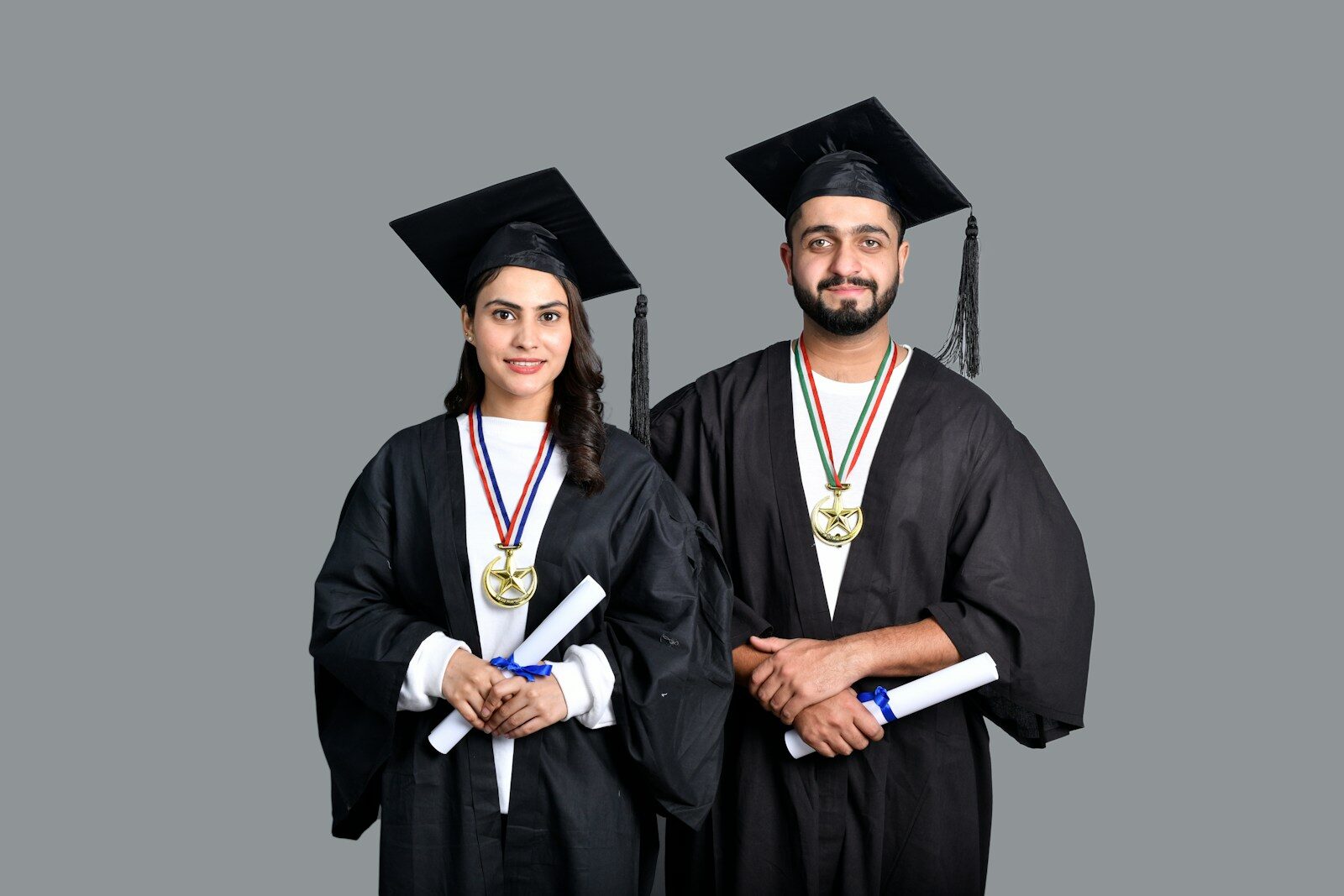 a man and woman wearing graduation gowns and caps